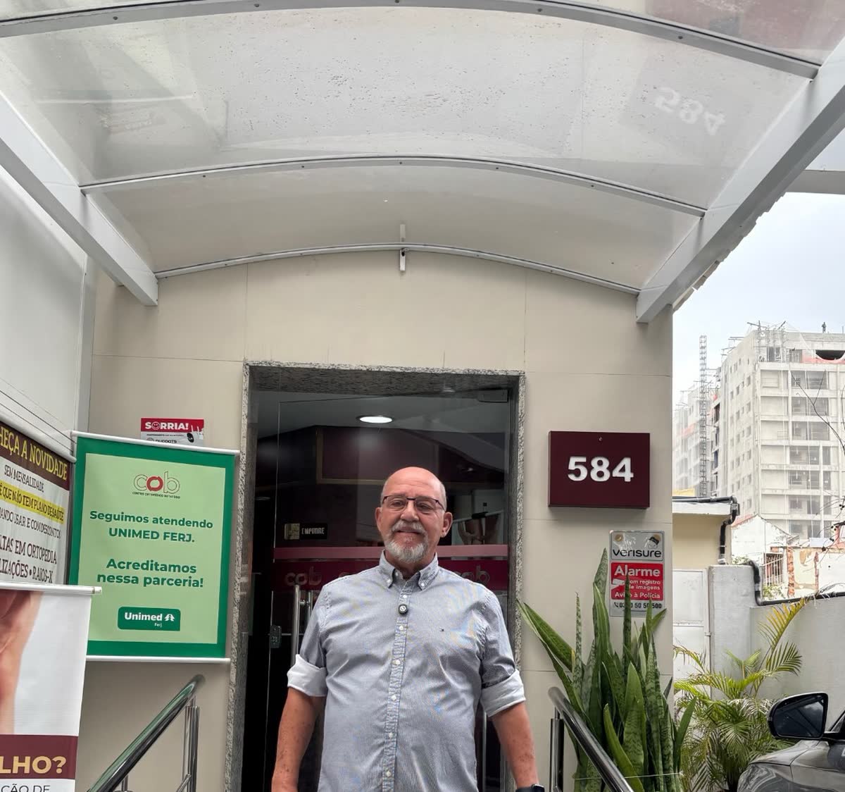 Entrada da clínica no número 584, com o portão aberto e a placa de convênio
